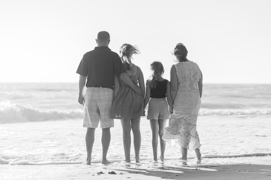 Photo by Freddy G man and woman walking on beach during daytime